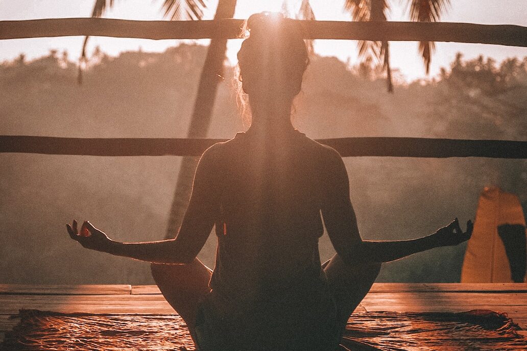 woman doing yoga meditation on brown parquet flooring