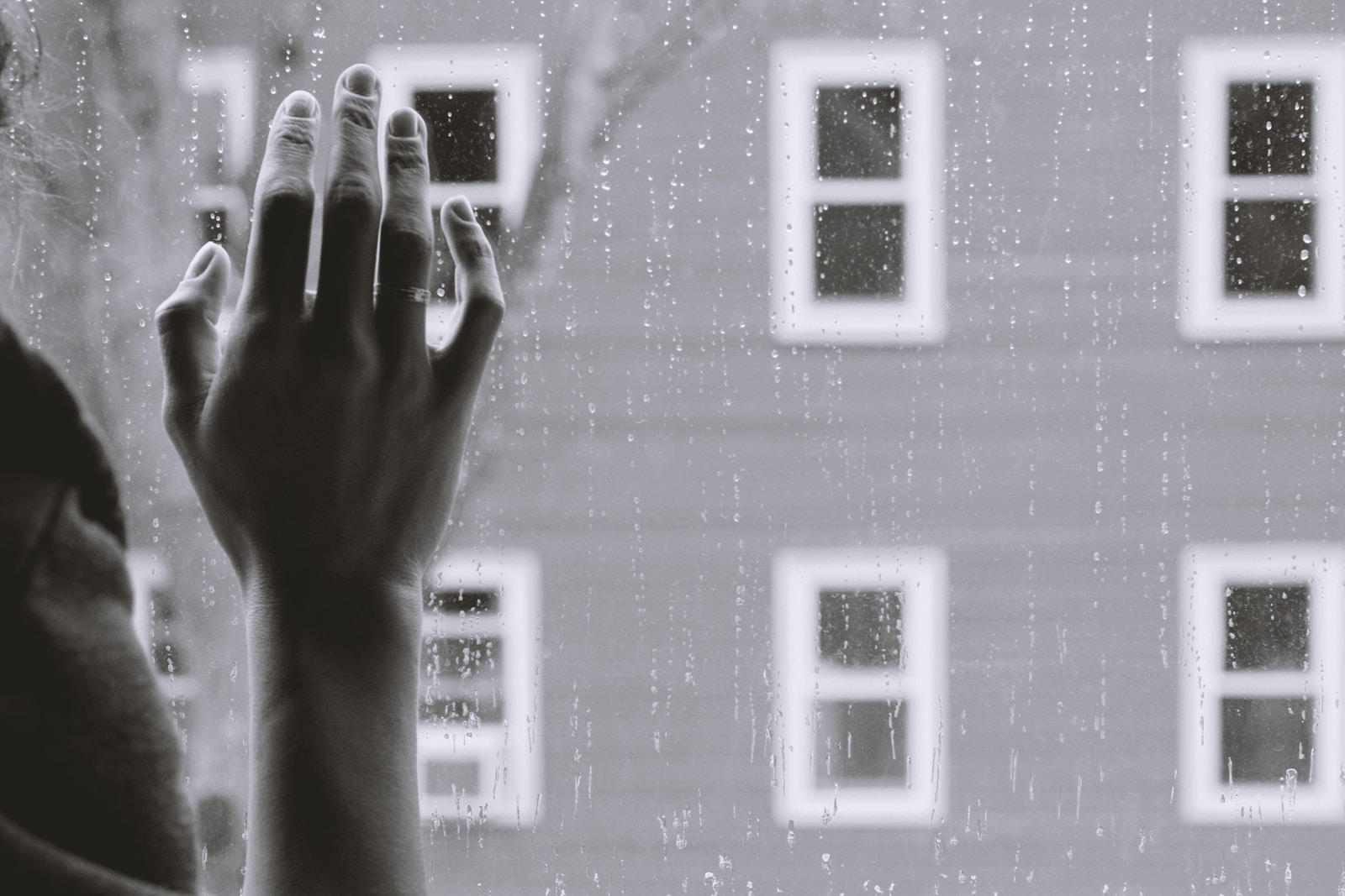 grayscale photo of woman right hand on glass